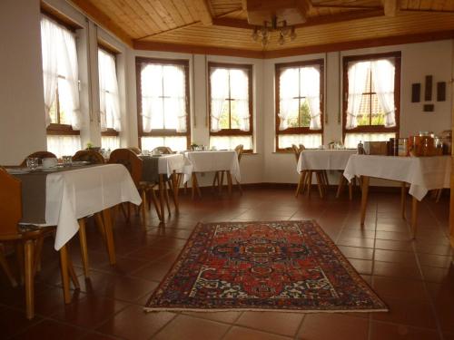 una sala da pranzo con tavoli, sedie e finestre di Hotel Glück a Ebersbach an der Fils