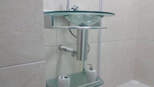 W łazience znajduje się szklana umywalka i toaleta. w obiekcie Condomínio Mandakaru Residence 12 w mieście Porto de Galinhas