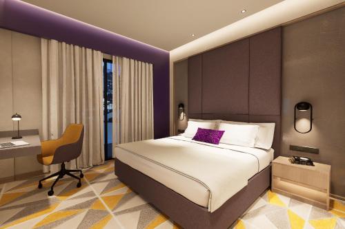 a bedroom with a bed and a desk and a chair at Vivanta Gurugram Sector 95A in Gurgaon