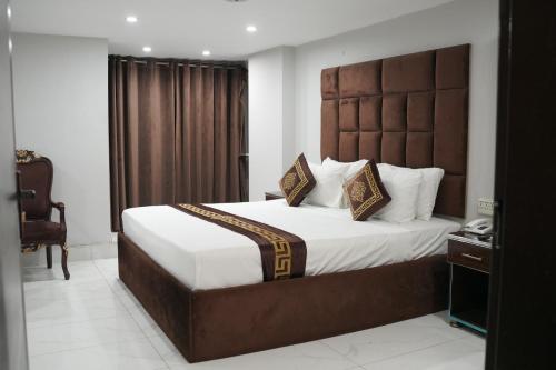 a bedroom with a large bed with a large headboard at Hotel Shanze Palace in Lahore
