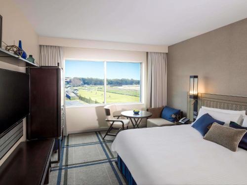 ein Hotelzimmer mit einem Bett und einem großen Fenster in der Unterkunft The William Inglis Mgallery in Warwick Farm