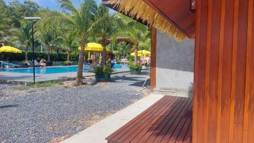 a resort with a pool and palm trees and umbrellas at Chomview Lanta Water Park Resort in Ko Lanta