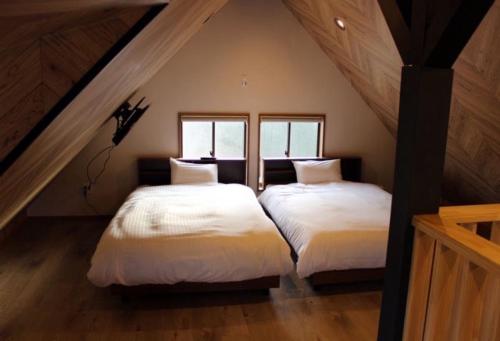 twee bedden in een zolderkamer met twee ramen bij BOTH ISUMI - Vacation STAY 06892v in Isumi