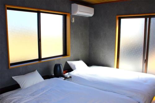 deux lits dans une chambre avec deux fenêtres dans l'établissement BOTH ISUMI - Vacation STAY 06928v, à Isumi