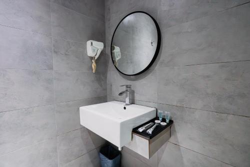 een badkamer met een witte wastafel en een spiegel bij Hotel 99 Seri Kembangan Serdang in Seri Kembangan