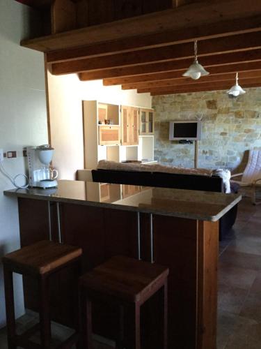 a kitchen with a counter and stools in a room at El Mirador de los Trobos in Villar de Otero