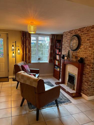 a living room with a couch and a fireplace at Cute and cosy cottage in the lovely Oxton village in Birkenhead