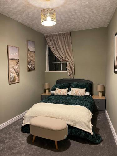 a bedroom with a large bed and a window at Cute and cosy cottage in the lovely Oxton village in Birkenhead