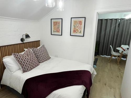 a bedroom with a bed with two pillows on it at Layover on Loerie in Cape Town