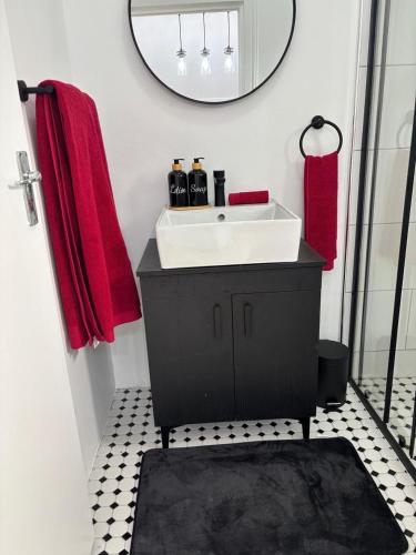 a bathroom with a white sink and a mirror at Layover on Loerie in Cape Town