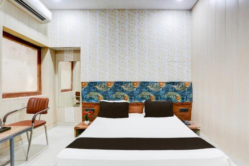 ein Schlafzimmer mit einem weißen Bett und einer blauen Wand in der Unterkunft Hotel O Heritage Inn in Prayagraj