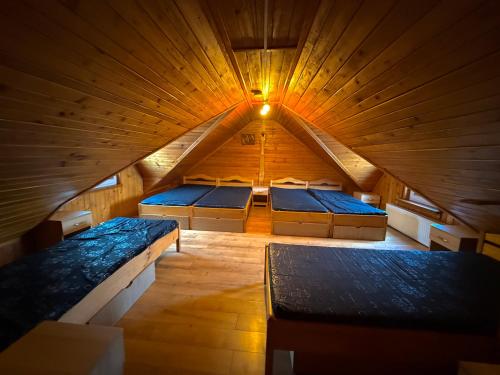 a large room with four beds in a wooden ceiling at Agro Ranczo - Domek na wynajem in Przysietnica