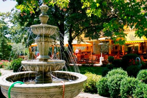 a fountain in the middle of a garden at Seibel's Park Hotel in Munich