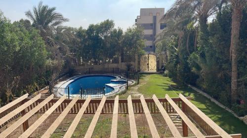 a swimming pool in a yard with trees and a building at فيلا كامله للايجار in Kafr Ghaţāţī