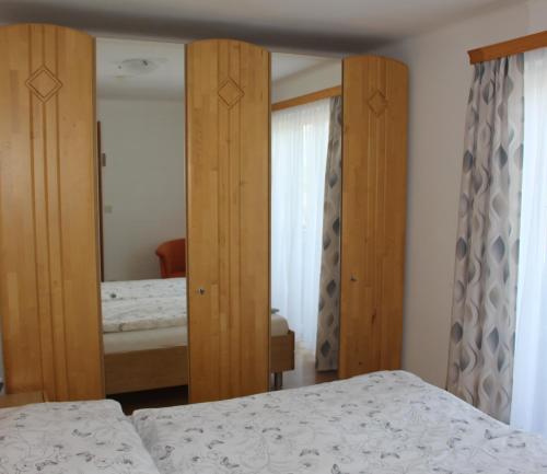 una camera da letto con due letti e uno specchio di Haus Bruschek a Sankt Gilgen