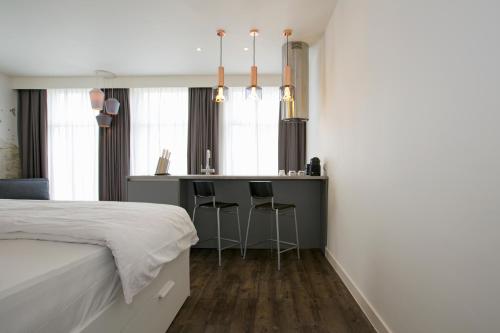 a bedroom with a bed and a bar with stools at De With Studio's in Rotterdam