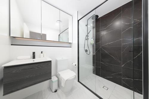 a bathroom with a shower and a toilet and a sink at Modern 2BR Free parking near Olympic park in Sydney