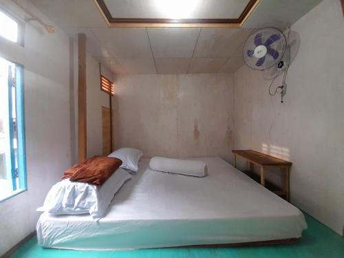 een bed in een kleine kamer met een ventilator bij Homestay Komodo Paradise in Pulau Komodo