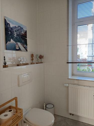a white bathroom with a toilet and a window at Familie Lehmann in Gera