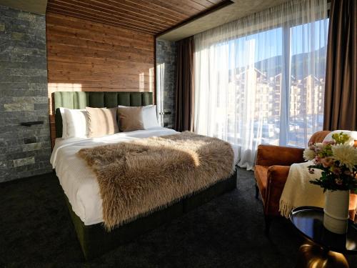 une chambre avec un grand lit avec une grande fenêtre dans l'établissement Premier Luxury Mountain Resort, à Bansko