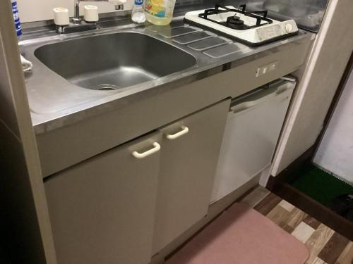 a kitchen with a sink and a stove at 森のハイジ in Azumino