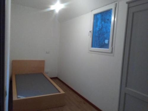 una camera con un letto e una finestra e una porta di La lanterna a Drena