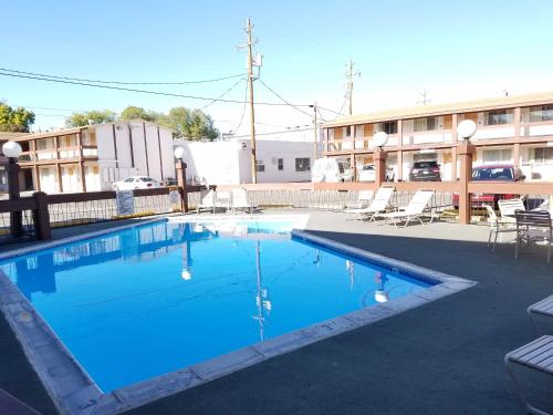 una piscina de agua azul frente a un edificio en Thunderbird Motel, en Elko