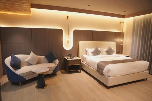 a hotel room with a bed and a chair at Love Kush Hotel in Kishangarh