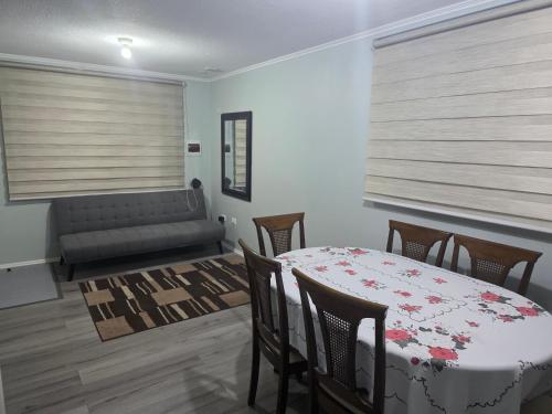 a living room with a table and chairs and a couch at Villa Parque Cordillera 1 in Chillán