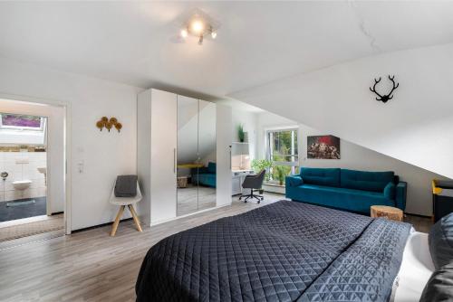 een slaapkamer met een bed en een blauwe bank bij Villa Eichwald Appartements in Freudenstadt