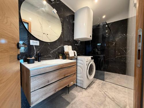 een badkamer met wastafel en wasmachine bij Green view apartment in Koper