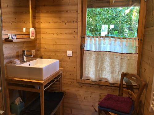 een badkamer met een wastafel en een raam bij Chalet la Cabane d'Ernestine, petit-déjeuner inclus in Les Villards-sur-Thônes