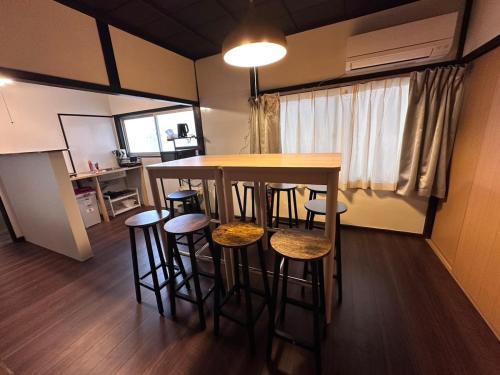 a kitchen with a table and stools in a room at Katata Biwa House in Otsu