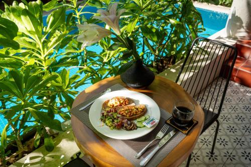 een bord eten op een tafel met een vaas bij La ALBA An Bang Beach Villa in Hội An