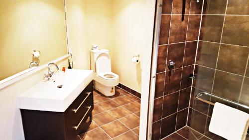 a bathroom with a toilet and a sink and a shower at Auckland Airport Kiwi Hotel in Auckland