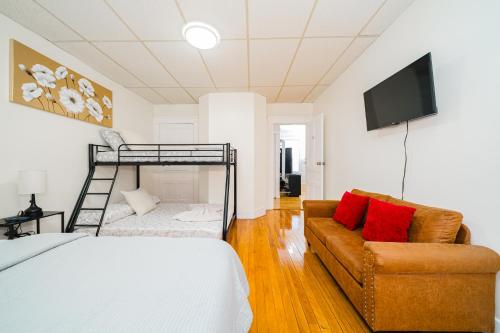 a bedroom with a bunk bed and a couch at Cozy 3BR Worcester 1st-floor Apt, Pet-Friendly, Near Clark University, Free Parking 4-1 in Worcester