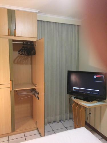 a room with a tv and a small desk with a tvictericter at Apart Quartier Latin Hotel in Vitória