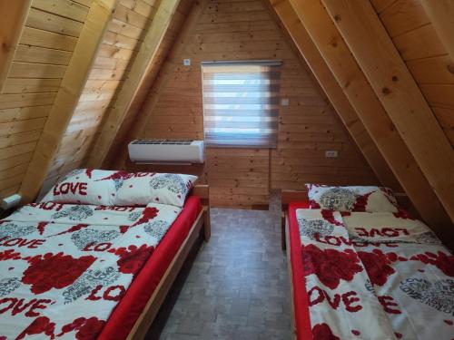 een slaapkamer met 2 bedden op een zolder bij Zaovinski Raj Tara in Konjska Reka