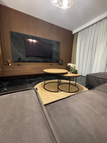 een woonkamer met een tafel en een groot scherm bij Long Beach, İskele, Grand Sapphire Resort - Pool View Luxury Studio in Paralimni