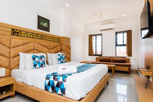 een slaapkamer met een groot bed en een bank bij HOTEL GALAXY SURAT in Surat