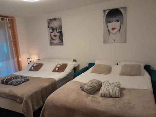 two beds in a room with pictures on the wall at San's resort in Vionnaz