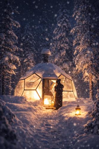 a person standing next to a igloo in the snow at Aurora Igloo Village Ylläs - Hot Tub in Ylläsjärvi