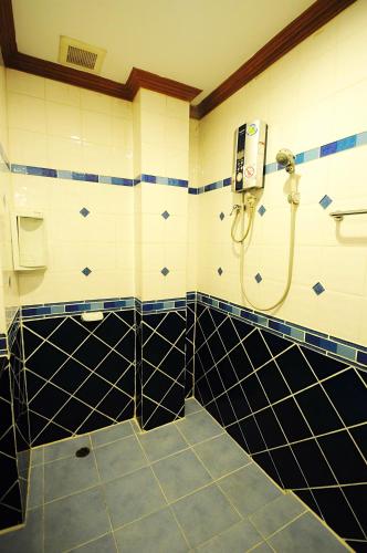 a bathroom with a shower with black and white tiles at Alina Grande Hotel & Resort in Ko Chang