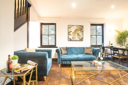a living room with a blue couch and tables at Northern Hideaways Apple Store, Ellingham in Chathill