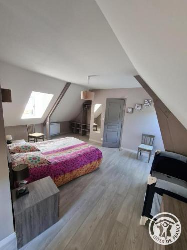 a attic bedroom with a bed and a table at Le chapelou in Égletons