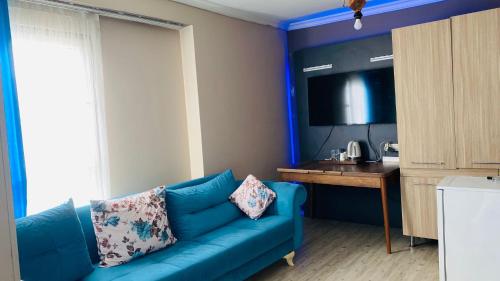 een woonkamer met een blauwe bank en een tafel bij Ay suit in Esenyurt
