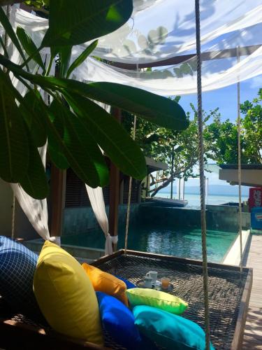 a swing in front of a swimming pool at Chantaramas Beach Resort Koh Phangan in Baan Khai