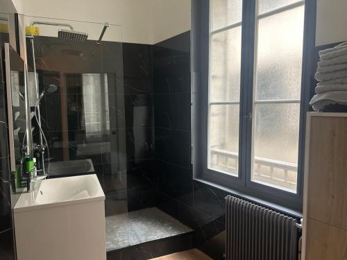 une salle de bain avec un lavabo et une fenêtre dans l'établissement le Limo: logement cosy en hyper centre, à Périgueux