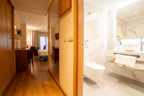 ein Badezimmer mit Toilette und Waschbecken in der Unterkunft Aparto-Hotel Rosales in Madrid