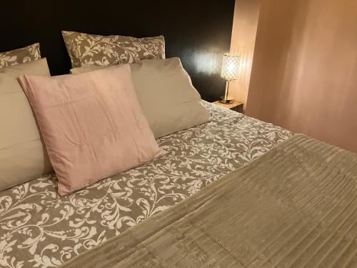 een bed met twee kussens en een deken erop bij Amis Wine House in Pomerol